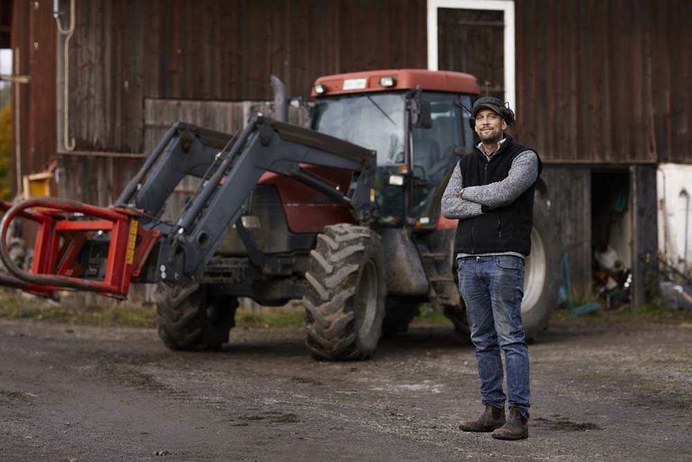 Man med en traktor i bakgrunden