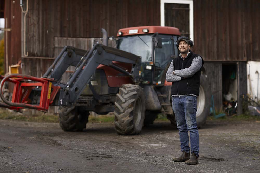 Man med en traktor i bakgrunden